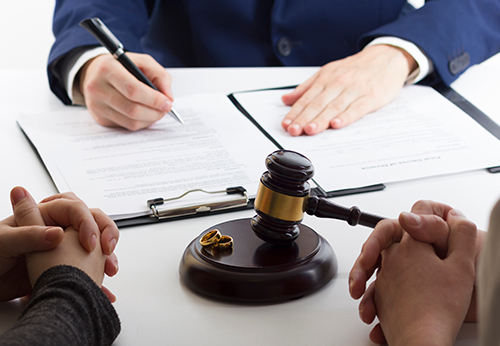 Divorce lawyer discussing settlement with couple.